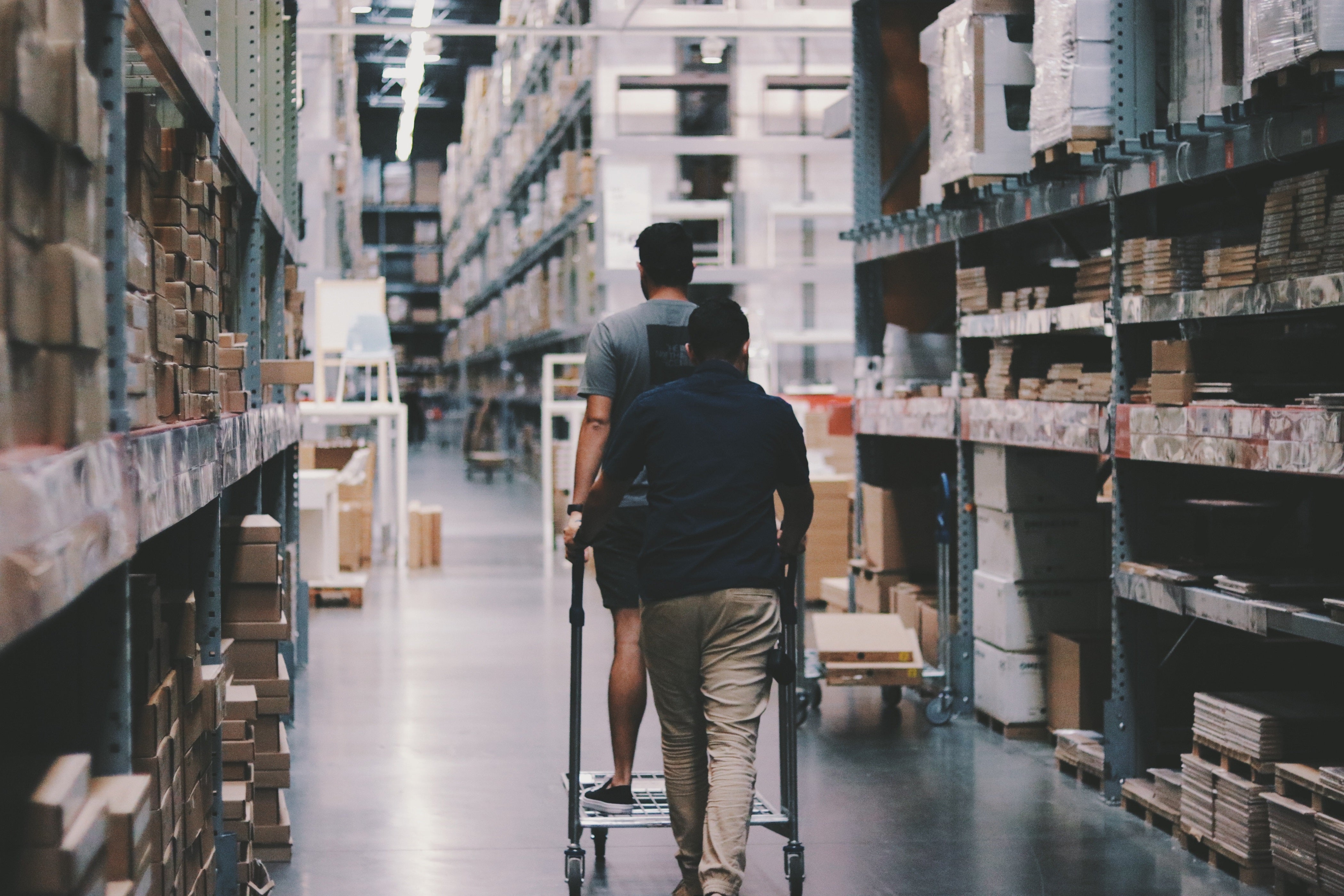 People pushing a trolley in a warehouse